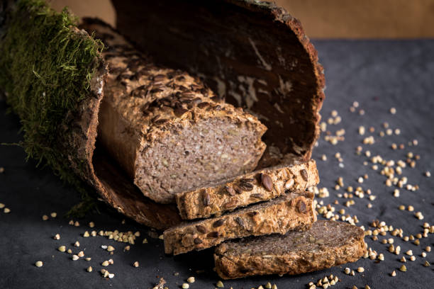 Home made vegan buckwheat bread on dark background with grains. Freshly baked gluten free bread in slices stock photo