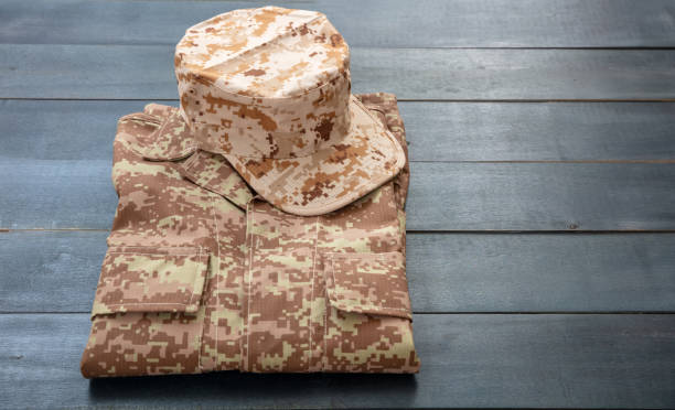 istock US army cap on a folded uniform, blue color background. 1267698344