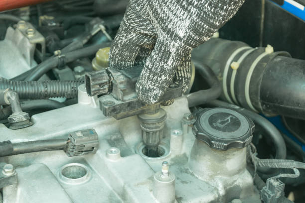 istock Remove damaged ignition coil on my car engine, Auto mechanic maintenance ignition system. 1267699785