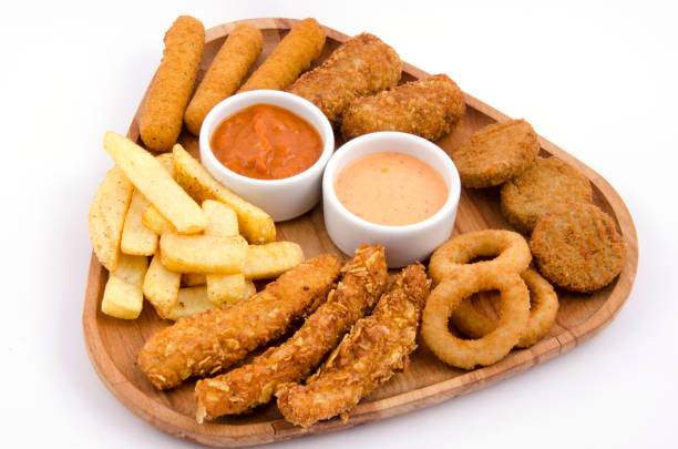 istock fried snacks on wooden platter on back white background 1267700816