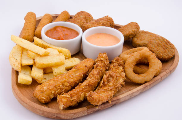 istock fried snacks on wooden platter on back white background 1267701107