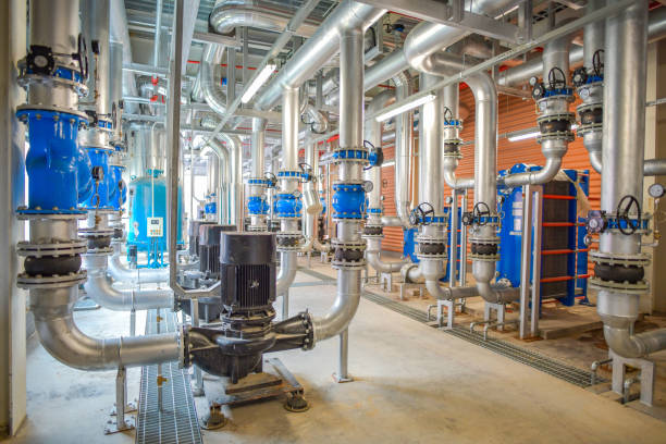 Industrial interior chiller and boiler system room of equipment heating system, pipelines system, water pump system, valves system, and manometers system at the large building in factory Industrial interior chiller and boiler system room of equipment heating system, pipelines system, water pump system, valves system, and manometers system at the large building in factory piping hot stock pictures, royalty-free photos & images