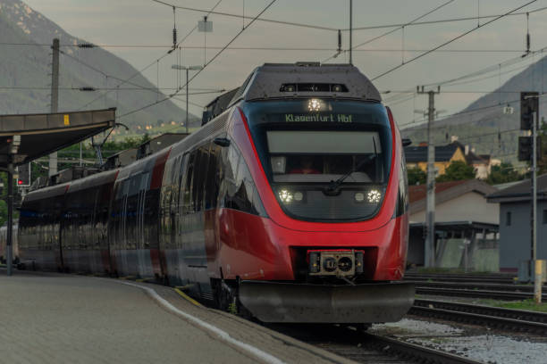 Villach station with electric red passenger unit in summer sunny morning Villach station with electric red passenger unit in summer sunny hot morning villach stock pictures, royalty-free photos & images