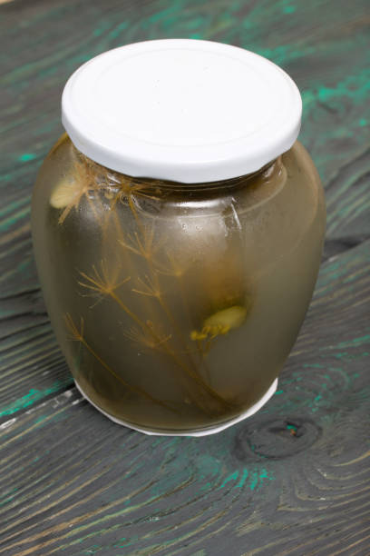 istock Jar of pickled cucumbers. On a painted board surface. 1267702143