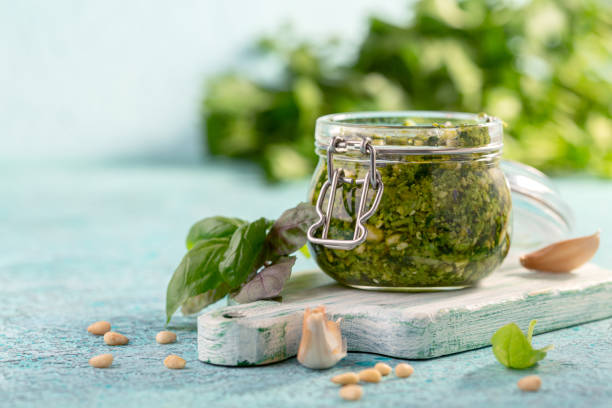 istock Fresh basil pesto sauce in glass jar. 1267703113