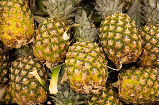 Lots of pineapple fruit background top view, tropical fruits in supermarkets. Copy of the space.
