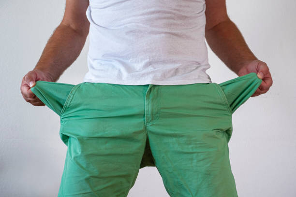 istock A man in trousers with empty pockets turned out. On a blue and white background. 1267707940