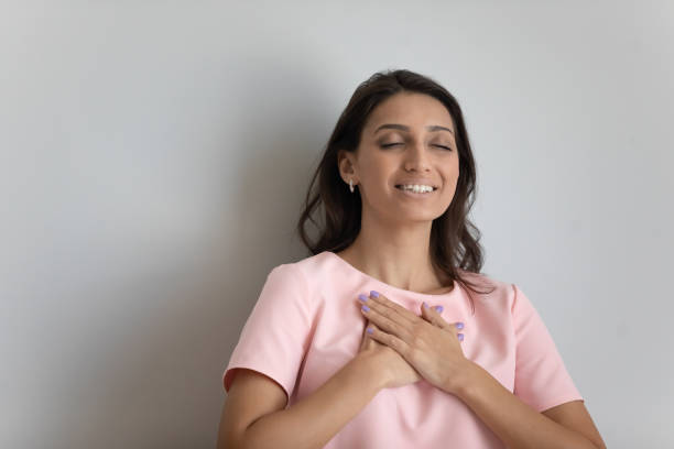 istock Grateful ethnic woman hold hands at chest feeling thankful 1267716576
