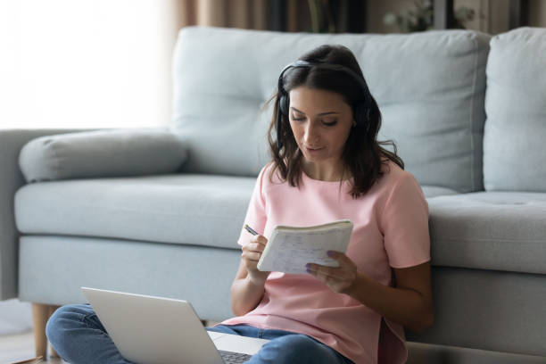 istock Ethnic woman in headphones make notes watching webinar on laptop 1267716577