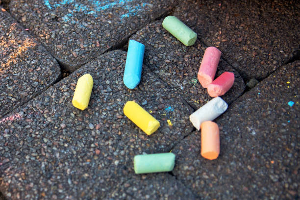 istock Blurred image Colorful pastel sidewalk chalk on dark asphalt background. children's crayons on the asphalt close up. The concept of development of children's creativity. selective focus. No focus 1267717768