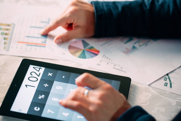 istock Close-up Of A Businessperson's Hand Analyzing Bill On Digital Tablet Over Desk. 1267719868