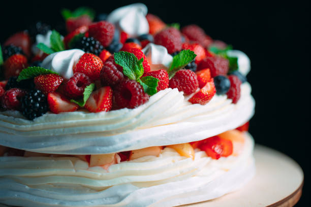 istock Fruit cake. Cake decorated with berries on a wooden stand on a black background. 1267723479