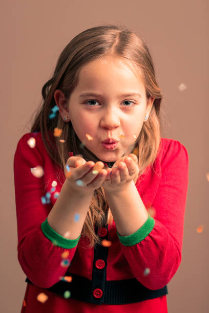 istock Girl celebrates blowing confetti 1267723593