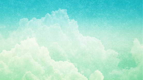 Panoramic Photograph - Cloudscape - Abstract background of fluffy cumulus clouds in pastel colors with copy space; design element, textured effect, noise added.