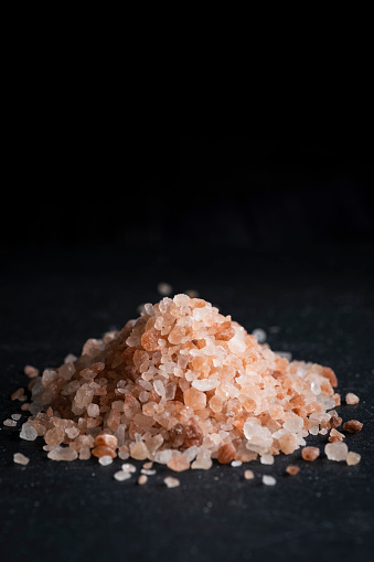 Pile of Pink Himalayan salt on slate with copy space.