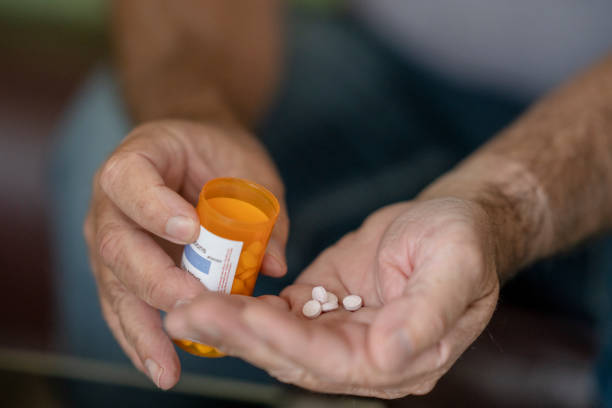 istock Senior male hands holding pill bottle 1267730940