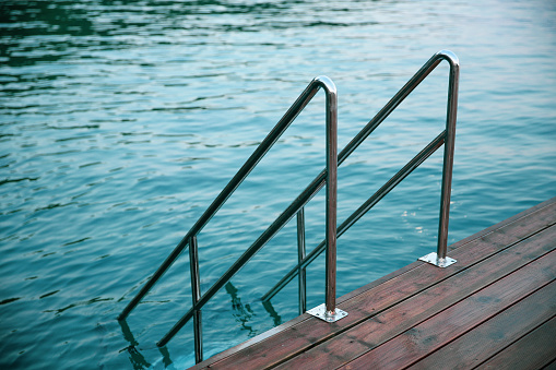 Metal staircase with handrail to the sea