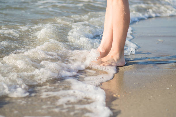 istock Women's legs are covered by the sea wave. 1267732163