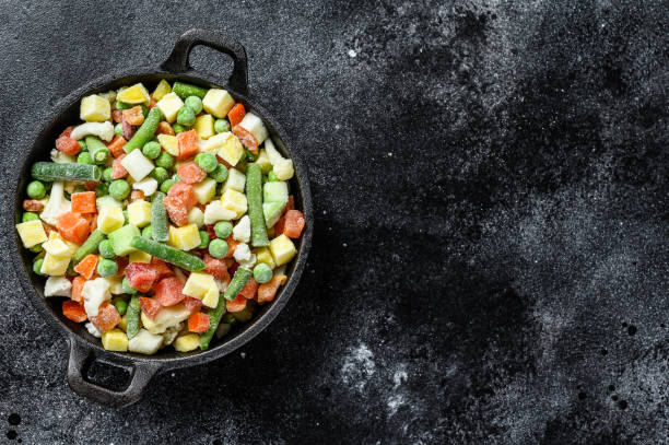 frozen vegetables. broccoli, cherry tomatoes, corn, pea, carrot.  black background. top view. copy space - edible mushroom frozen variation ice imagens e fotografias de stock