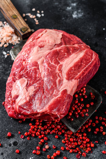 istock Fresh raw beef marbled steak. Chuck eye roll on a cleaver. Black background. Top view 1267735574