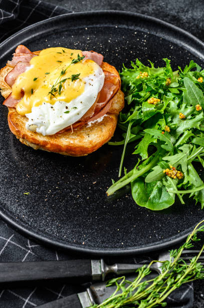 istock Breakfast Burger with bacon, egg Benedict, hollandaise sauce on brioche bun. Black background. Top view 1267737634