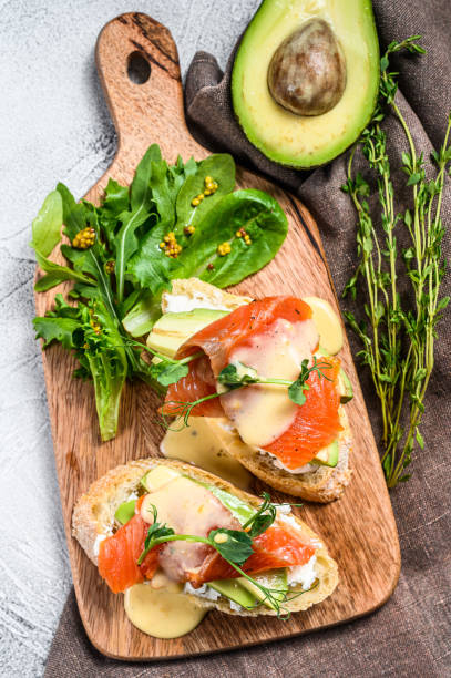 istock Toasts with avocado and smoked salmon.  White background. Top view 1267738153