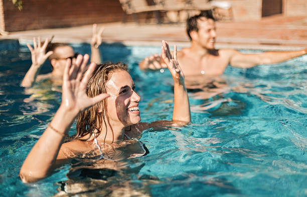 istock Friends having fun, playing volleyball in the swimming pool 1267739082