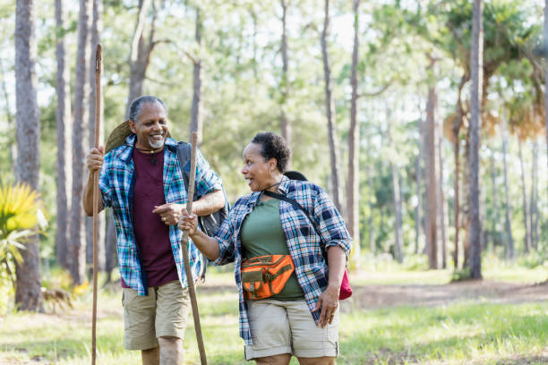 coppia afro-americana senior che escursioni nel parco - bag senior adult outdoors friendship foto e immagini stock