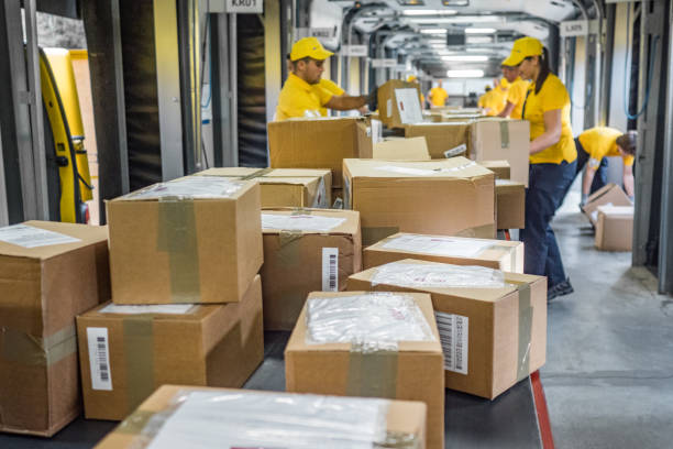 istock Postal workers handling packages at a conveyor belt 1267748026