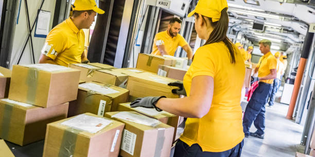 postal workers handling packages at a conveyor belt - post processing imagens e fotografias de stock