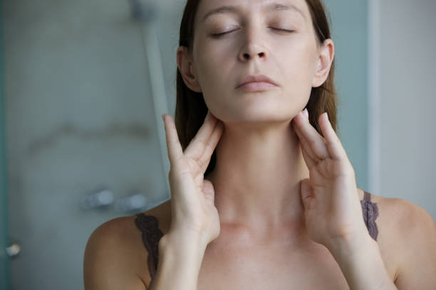 istock Young woman touching her throat. Sore throat, tonsillitis or thyroid gland problem. 1267749588