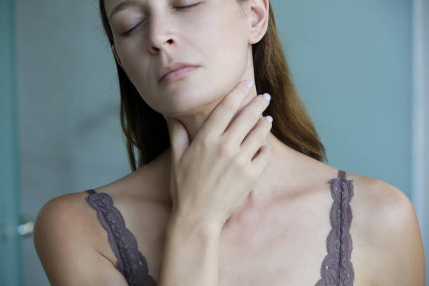 istock Young woman touching her throat. Sore throat, tonsillitis or thyroid gland problem. 1267750784