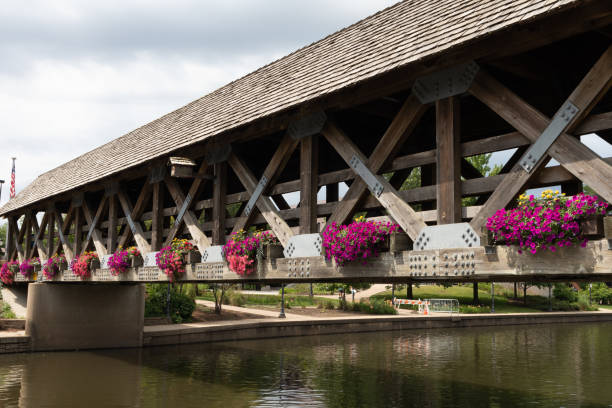 wooden covered bridge over the dupage river along the naperville riverwalk in suburban naperville illinois during summer - dupage imagens e fotografias de stock