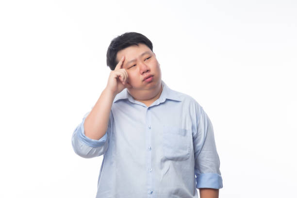 istock Young Fat Asian business man thinking with doubts face isolated on white background 1267771476