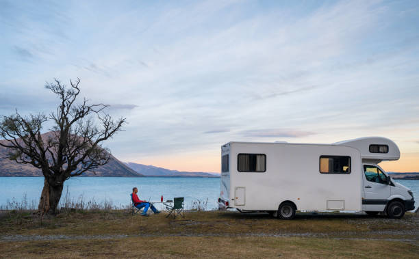 Man enjoying working from a remote place. During the Covid pandemic a man give himself working holiday and working from a remote place in South Island, New Zealand. camper trailer photos stock pictures, royalty-free photos & images