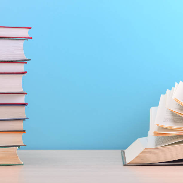 istock The book is open, the sheets are fan-shaped on a blue background next to a stack of books. 1267792829