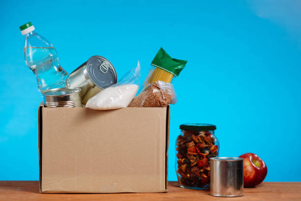 istock Donation box full of different products on blue background 1267795503