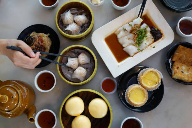 istock Flat lay Chinese dim sum, various traditional dim sum freshly served on table and human hands picking up with chopsticks 1267801739