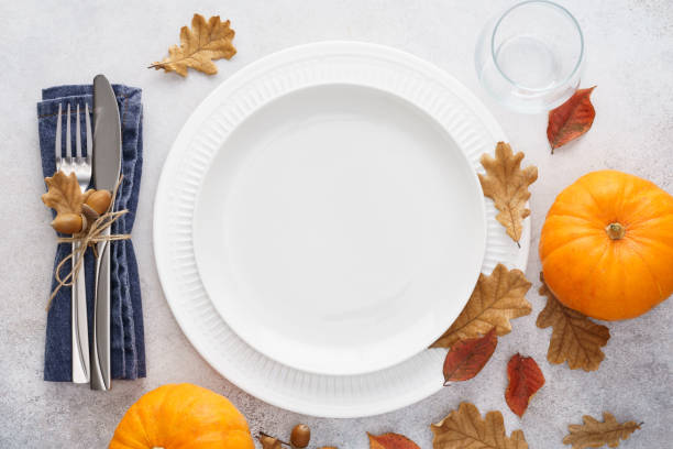 istock Fall season table setting with pumpkins, leaves and cutlery. 1267804586