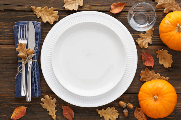 istock Fall season table setting with pumpkins, leaves and cutlery. 1267805324