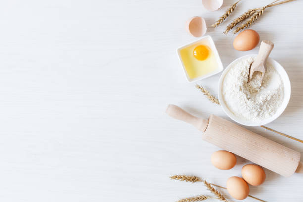 istock Ingredients and tools for dough preparation on white wooden background top view. B 1267811573
