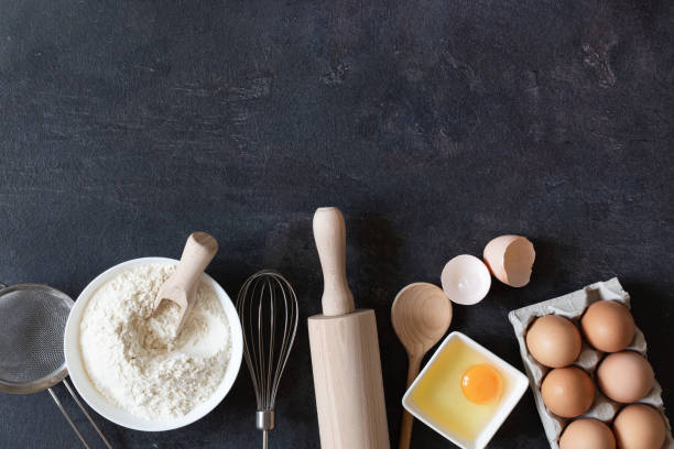 istock Ingredients and tools for dough preparation on black background top view. 1267811577