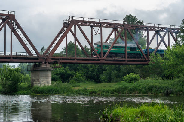istock Freight train rides on a railway bridge over the river 1267820901