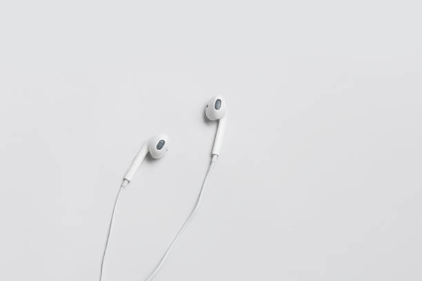 White wired earbuds resting on a clean surface, providing personal audio playback