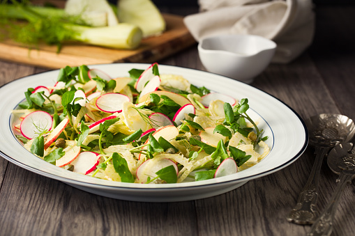 Homemade freshness sliced fennel, apple, and radish with watercress and capers service with balsamic vinegar olive oil dressing