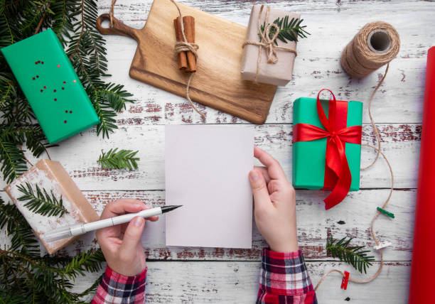 istock hands hold a pen and a postcard on the table next to gifts 1267833793