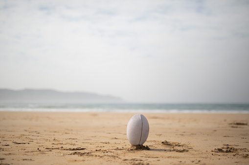 A rugby ball on a beach. The beach is close to Knysna, South Africa.