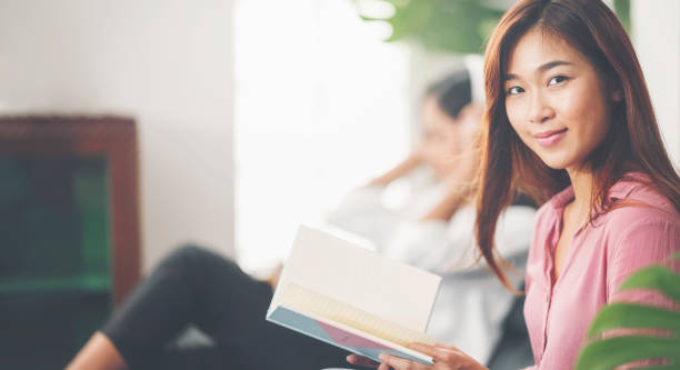 istock Young woman reading while staying at home with her friend. 1267863496