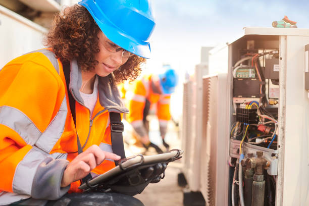 female electrician with aircon unit rooftop air con installation maintenance engineer fuel and power generation power line electricity stock pictures, royalty-free photos & images