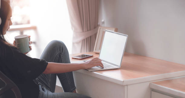 istock Young woman working with laptop while sitting in living room. 1267863575